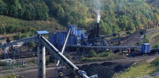 Industrial coal processing facility with conveyor belts and smoke stack