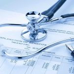 A stethoscope resting on a medical billing statement