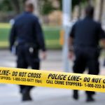 The 911 Confession That Stopped Officers Cold Police officers walking past caution tape at a crime scene