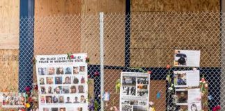 The Image That Went Viral Before Anyone Verified It Was Real A memorial display with photos and flowers on a fence