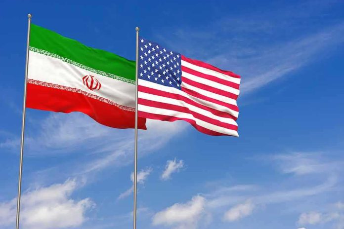 shutterstock_1119027908 Iran and United States flags waving on flagpoles