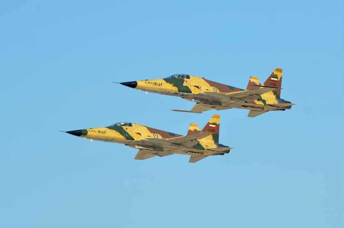shutterstock_1534535717 Two fighter jets flying in formation against a clear blue sky
