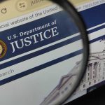 Close-up view of the U.S. Department of Justice website through a magnifying glass