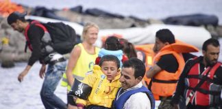Flood Alerts Blared — Families Still Trapped man in life vest carrying a child from a boat landing