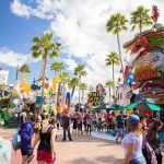 Crowd walking through a cartoon-themed amusement park street