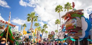 Crowd walking through a cartoon-themed amusement park street