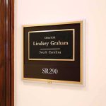The Senator Who Wants Washington Back in the Abortion Fight office wall plaque with black and gold nameplate and room number