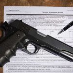 Federal Gun Registry Just Lost Its Teeth Handgun on a firearms transaction form with a pen
