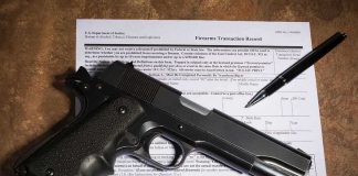 Federal Gun Registry Just Lost Its Teeth Handgun on a firearms transaction form with a pen