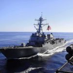 Iran Retaliates: Tankers Marked For Trouble naval destroyer sailing at sea with flag flying