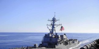 Iran Retaliates: Tankers Marked For Trouble naval destroyer sailing at sea with flag flying