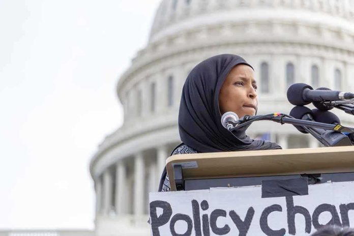 shutterstock_1355305115 Woman in hijab speaking at podium with microphones outside a domed building