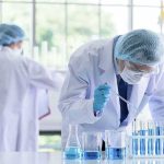 Biosecurity Jitters After AI Virus Leap Scientist pipetting blue liquid into test tubes in a laboratory