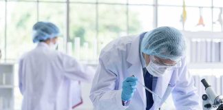 Biosecurity Jitters After AI Virus Leap Scientist pipetting blue liquid into test tubes in a laboratory