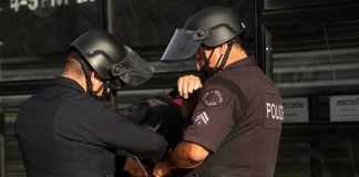 Police officers handcuff a person during an arrest
