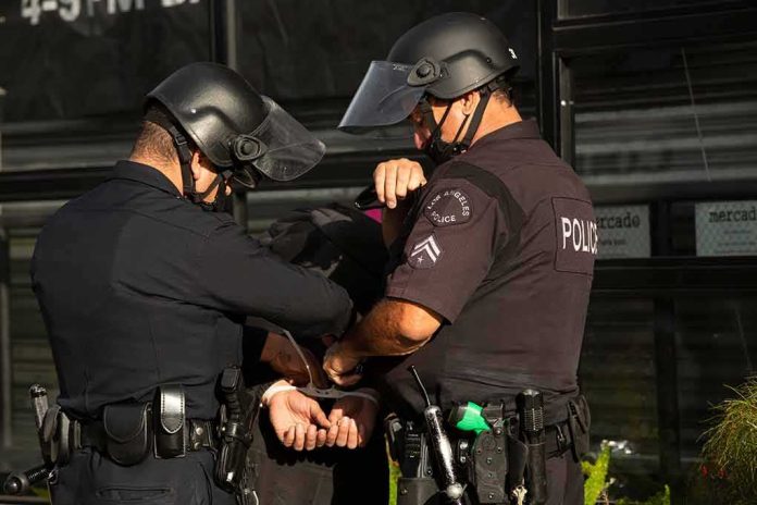 shutterstock_1752951593 Police officers handcuff a person during an arrest