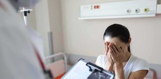 Barely There, Then Bone Spread Woman covering her face while doctor holds a clipboard in a hospital room