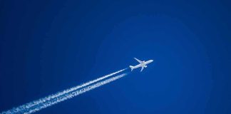 Atlantic Air Lanes Quietly Get a Climate Overhaul Airplane leaving contrails in a clear blue sky