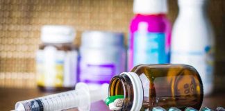 Funding Cutoff Hits Trans Kids—Hospitals Flinch Medicine pills and syringe on table with brown bottle