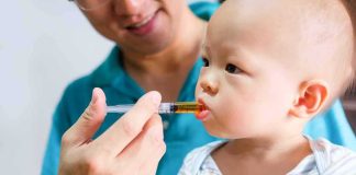 Clinic Language War Ignites Maine Firestorm Baby taking liquid medicine from an oral syringe held by an adult