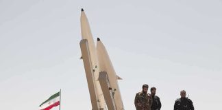 Negotiations? Or Just Stalling? soldiers stand beside large missiles at outdoor display