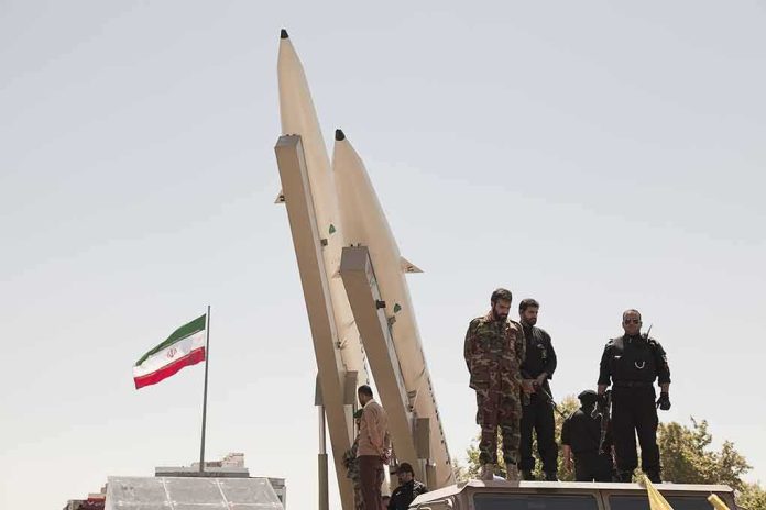 shutterstock_681421708-1 soldiers stand beside large missiles at outdoor display