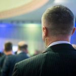 Man with earpiece at a crowded event.