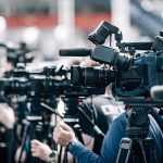 Wisconsin Shock: Higher Than California Broadcast cameras on tripods at a press event