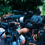 Jury Said Guilty — Governor Said Go TV news cameras crowding together at an outdoor event