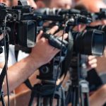 television cameras on tripods at a media event