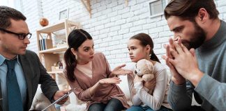 Family and counselor in tense discussion with upset child holding teddy bear