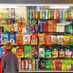 Junk Food’s Alarming Brain Impact Revealed Child looking at a shop window filled with snacks and cereals