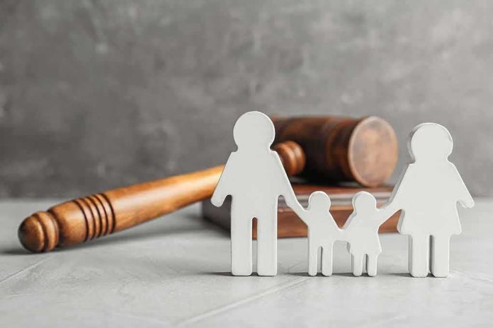 shutterstock_1108958093 Family cutout figures with judge's gavel in background