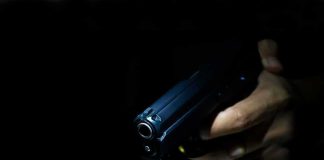 Hand holding a handgun in low light