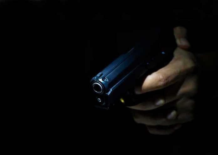 Hand holding a handgun in low light
