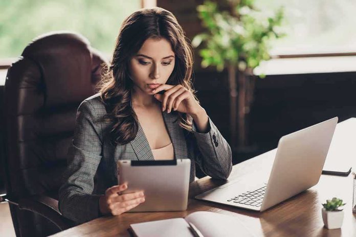 shutterstock_1162079794 Woman in office using tablet at desk