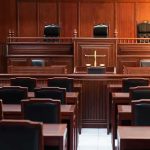 Empty courtroom with wooden benches and judge's bench