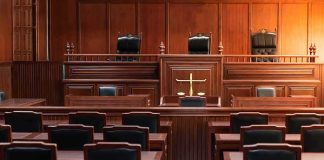 Empty courtroom with wooden benches and judge's bench