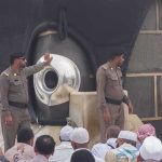 Sala Baker near two guards by the Kaaba’s Black Stone during pilgrimage