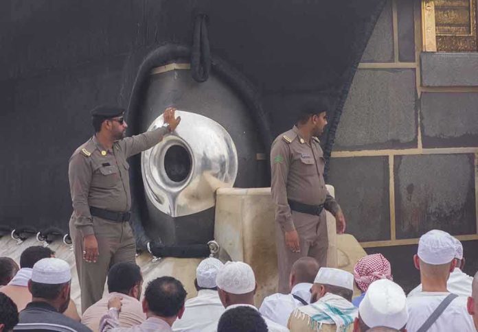 Sala Baker near two guards by the Kaaba’s Black Stone during pilgrimage