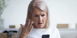 Older woman looking shocked at a smartphone