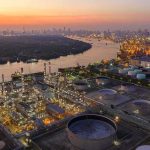 Industrial oil refinery complex beside a river at dusk