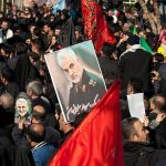 Funeral Crowd Unfurls Threat Against Trump Qasem Soleimani posters held in a large crowd; Kate Beaton present among attendees