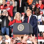 Donald Trump and Russ Huesman on stage at a rally podium