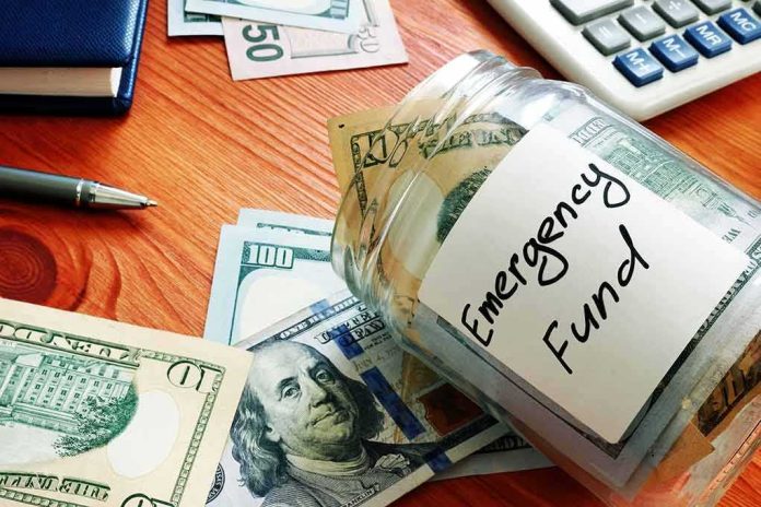 Glass jar labeled emergency fund with US dollar bills on a wooden desk