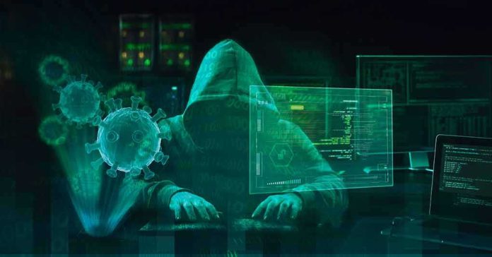 Hooded hacker at computer with digital virus graphics