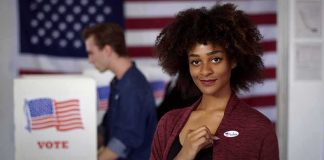 Voter showing an I Voted sticker at a polling place