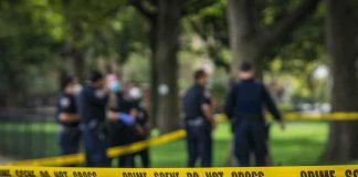 LAPD Confrontation: Pruning Blade, Then Gunfire crime scene tape with police officers in a park