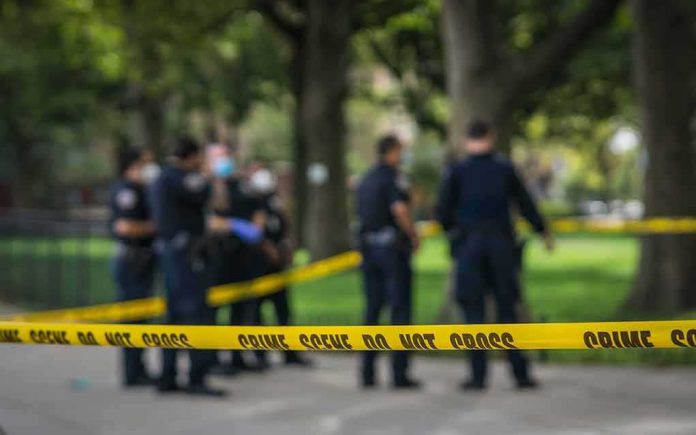 shutterstock_1814062073 crime scene tape with police officers in a park