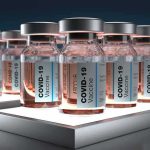 COVID-19 vaccine vials arranged in rows on illuminated shelves